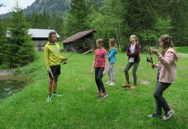 Der Outdoor-Ranger erklärt den Kindern den Umgang mit der Angel.