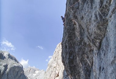 Die 6. Seillänge beginnt mit einer steilen und ausgesetzten Querung nach Links. Danach geht’s auf direktem Weg in die massive Plattenflucht der Headwall (c) Servus TV/Rudi Hauser