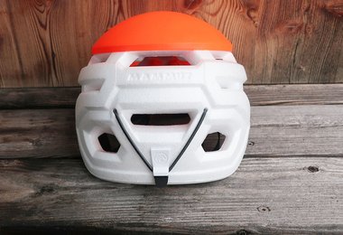 Die Stirnlampe wird hinten am Mammut Wall Rider Kletterhelm mit einem Gummi fixiert